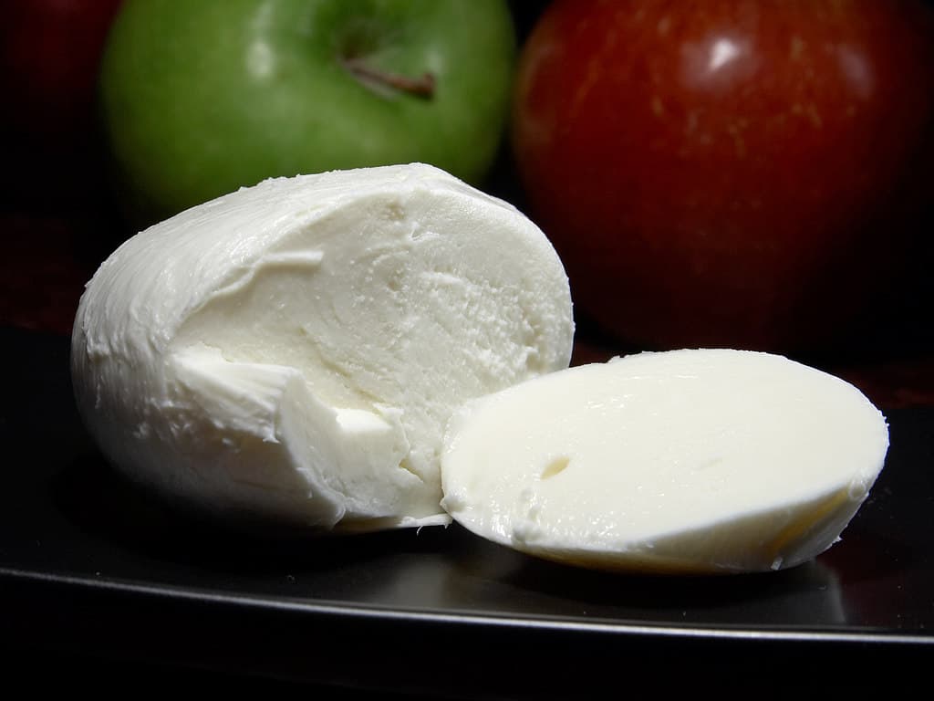 Bola de queijo mussarela fresca cortada ao meio, mostrando a massa branca e macia